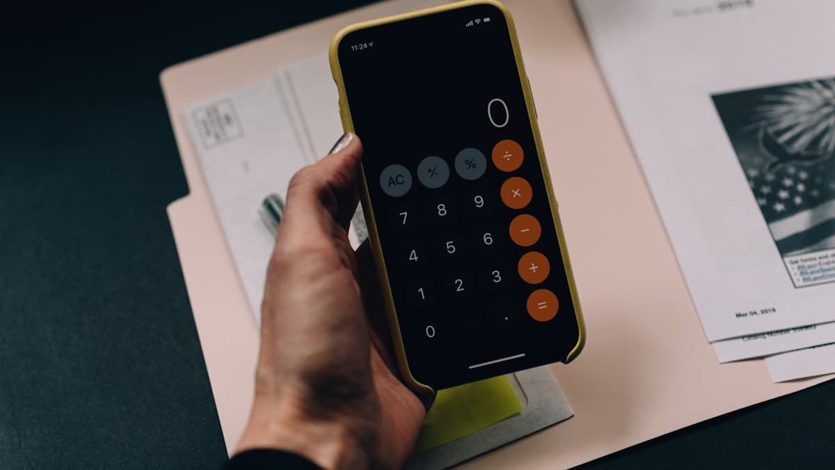Calculator and notepad on a desk, illustrating a ScreenPal review of plan costs